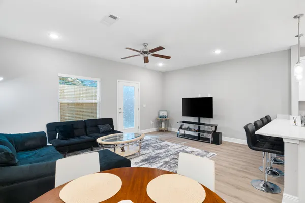 a living room with furniture a flat screen tv and kitchen view