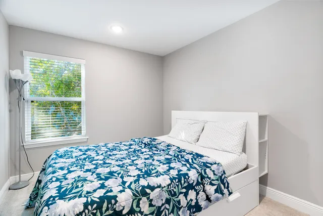 a bedroom with a large bed and a window