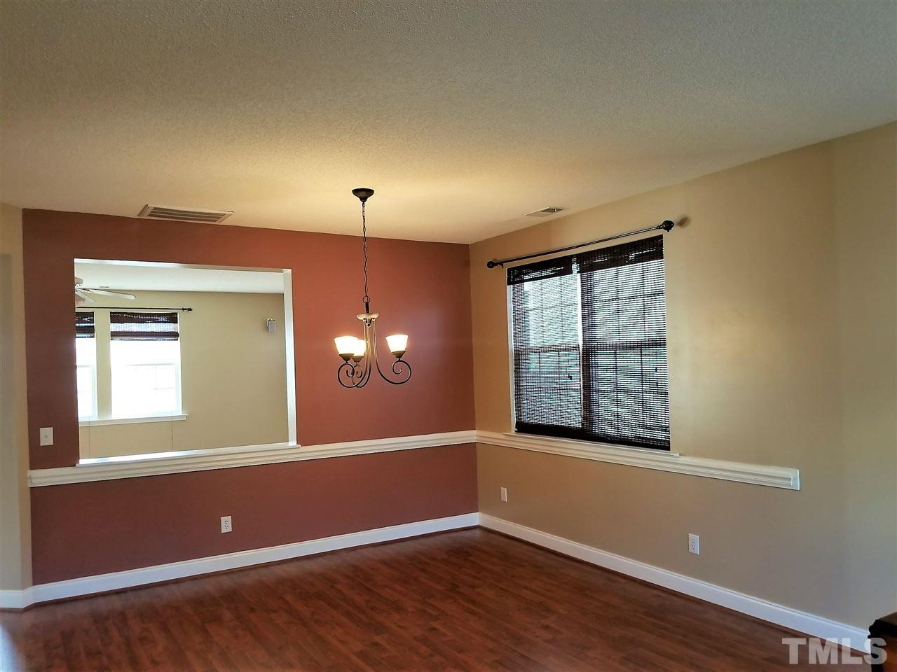 6044 Ricker Road Raleigh, NC 27610 - Photo 2 of 14 a view of empty room with wooden floor and fan