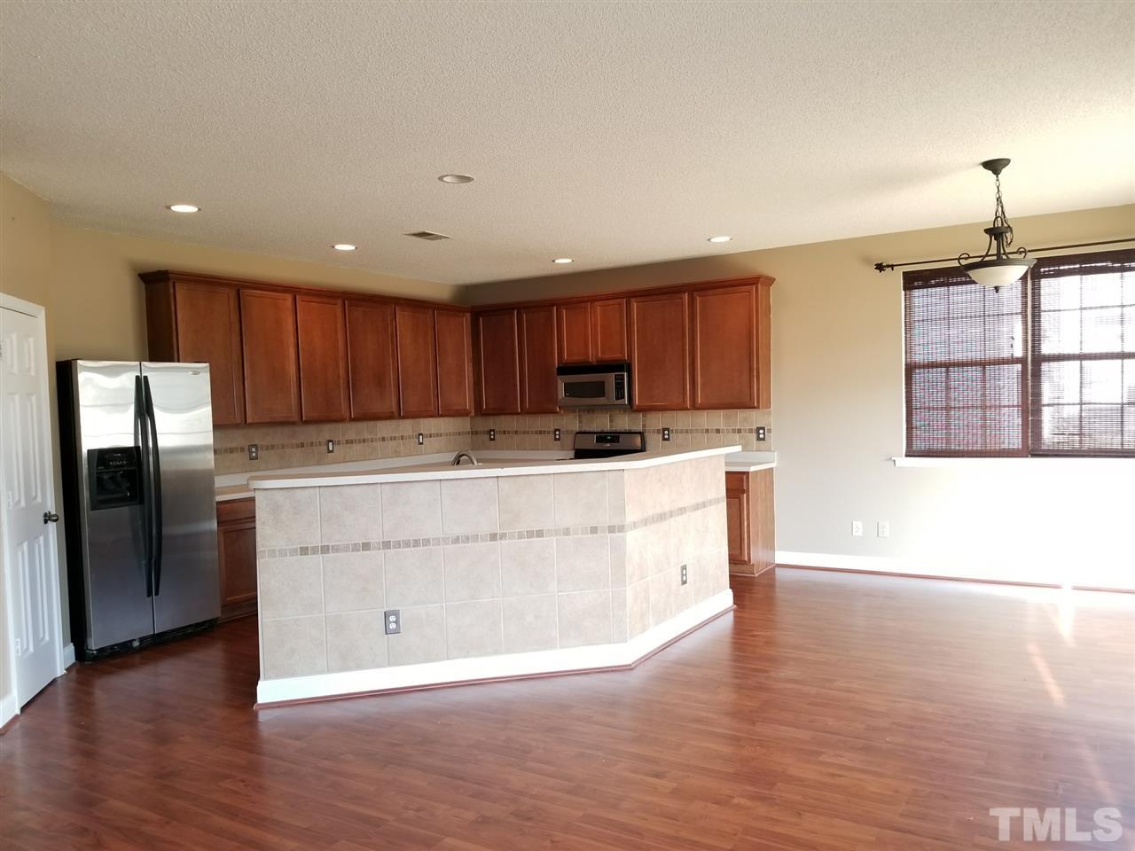 6044 Ricker Road Raleigh, NC 27610 - Photo 5 of 14 a kitchen with stainless steel appliances granite countertop a stove a sink and a refrigerator