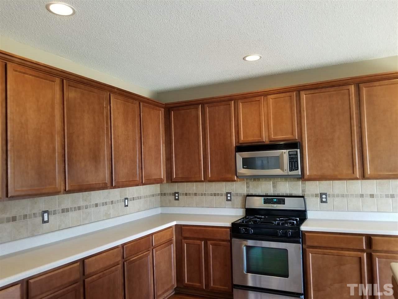 6044 Ricker Road Raleigh, NC 27610 - Photo 6 of 14 a kitchen with a sink stove and microwave