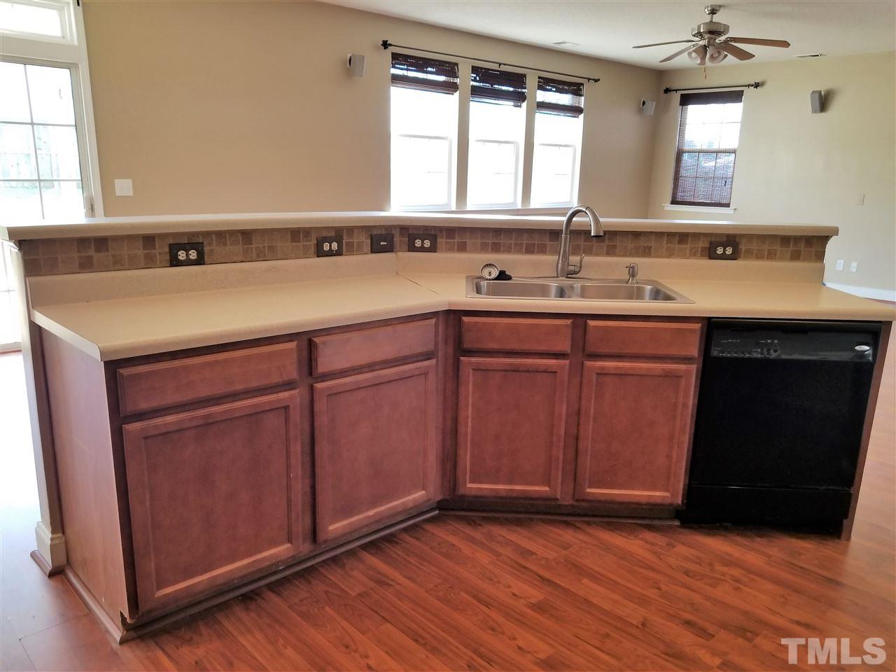 6044 Ricker Road Raleigh, NC 27610 - Photo 7 of 14 a sink with wooden cabinets