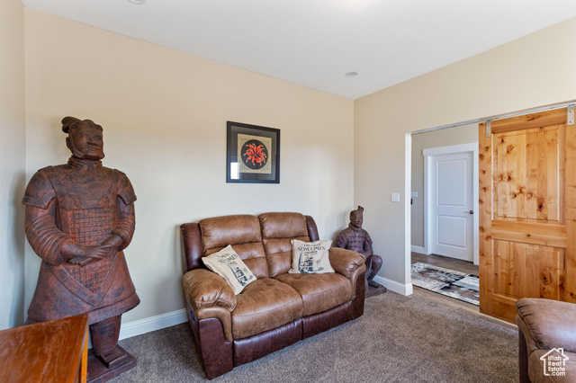 19502 South Olson Road Downey, ID 83234 - Photo 25 of 64 Carpeted living room featuring baseboards and a barn door
