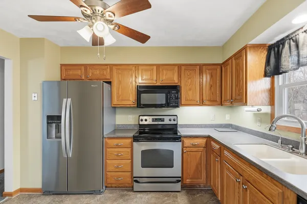 a kitchen with stainless steel appliances a sink cabinets and wooden floor
