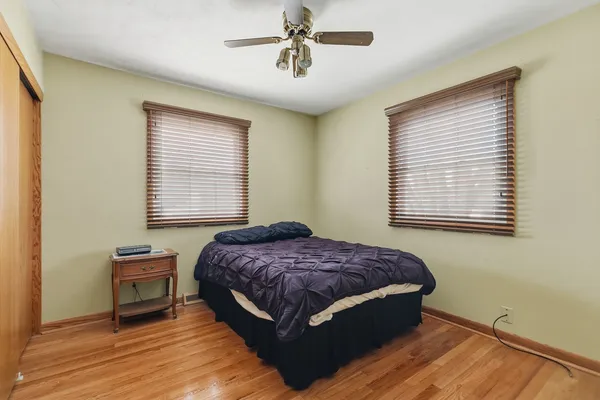 a bedroom with a bed and wooden floor