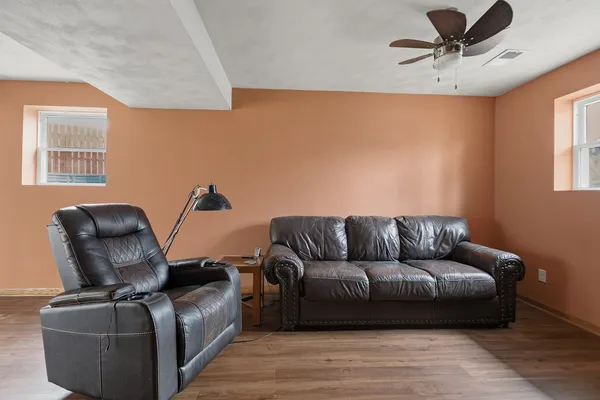 a view of a hallway with furniture and wooden floor