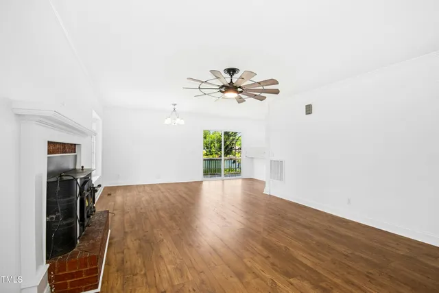 a view of a livingroom with wooden floor and a ceiling fan