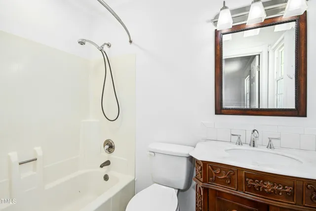 a bathroom with a granite countertop sink a toilet and a mirror