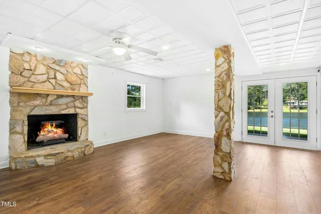 a view of empty room with wooden floor and a fireplace
