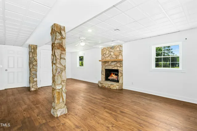 an empty room with windows and fireplace