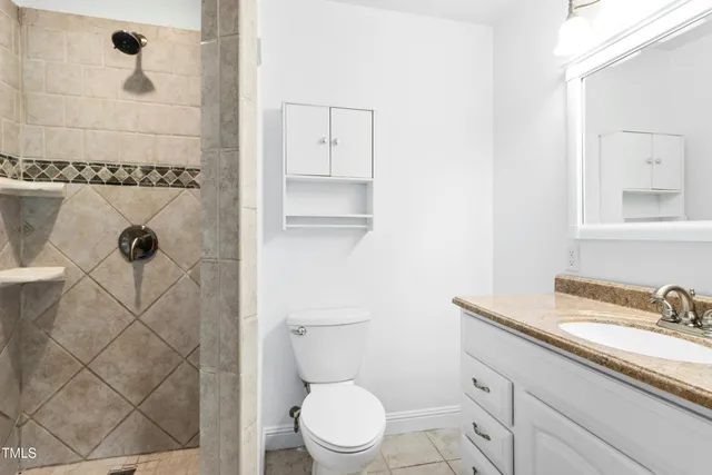 a bathroom with a granite countertop sink toilet and shower
