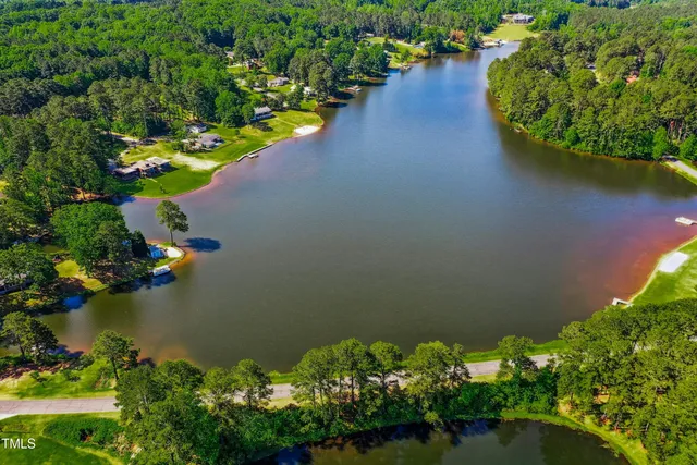 an aerial view of a house with a yard and lake view