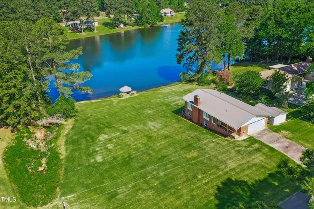 an aerial view of a house with a yard and lake view