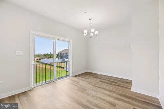 en empty room with floor to ceiling window and an outdoor view