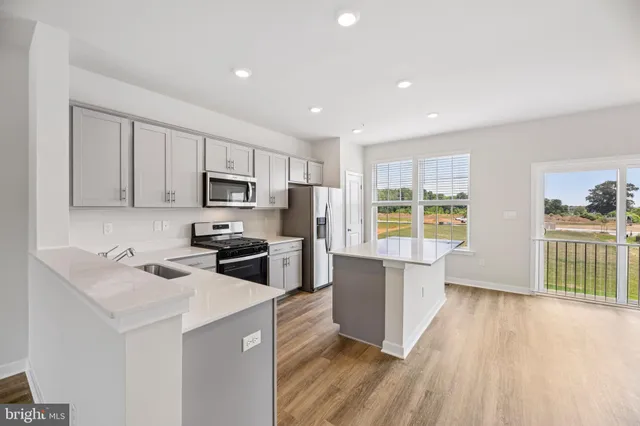 a kitchen with wooden floors and wooden cabinets