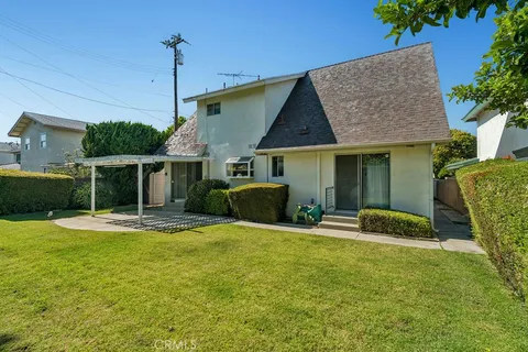 a view of a house with backyard and sitting area