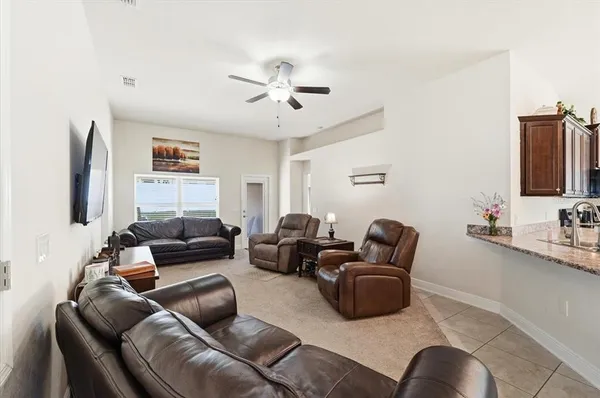a living room with furniture ceiling fan and a wooden floor