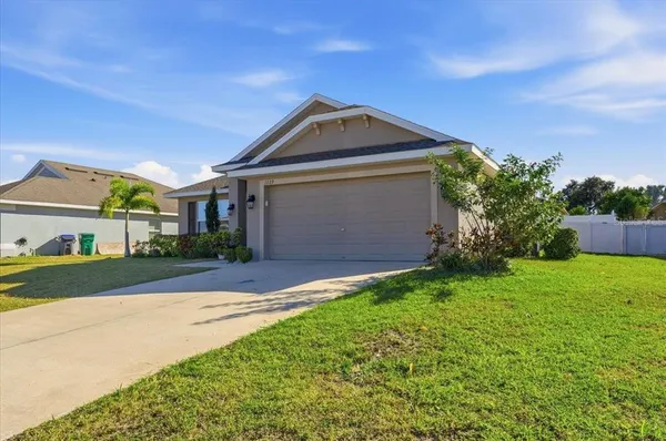 a front view of a house with a yard and garage