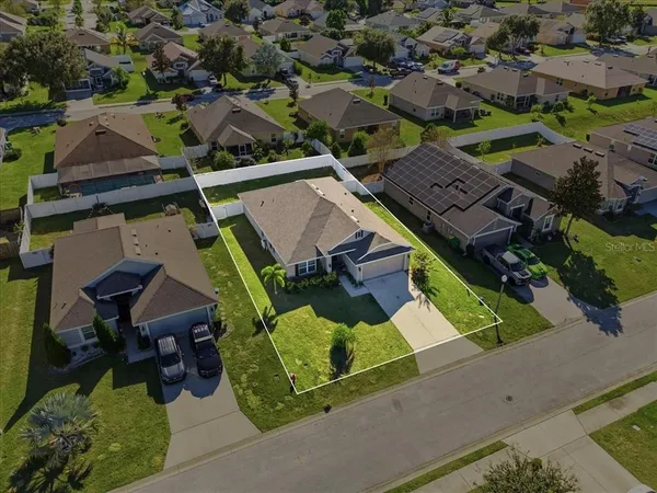 an aerial view of a house with garden space and street view