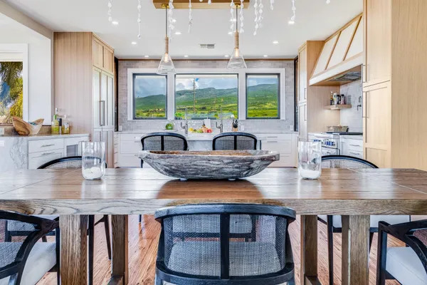 a kitchen with granite countertop a table chairs stove and wooden floor