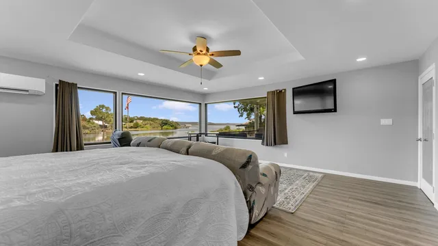 a bedroom with a bed and a flat tv screen on dresser