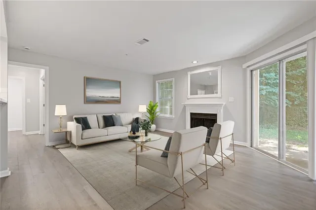 a living room with furniture a fireplace and a floor to ceiling window