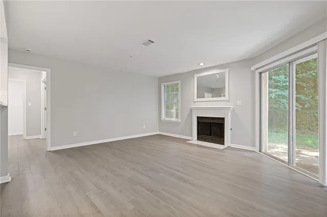 wooden floor fireplace and natural light in room