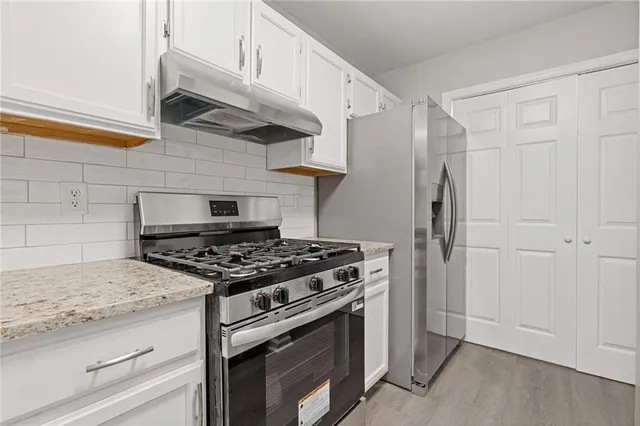 a kitchen with stainless steel appliances granite countertop a stove and a refrigerator