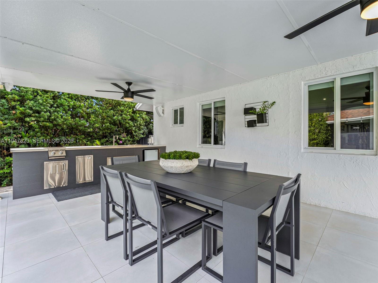 7753 Northwest 189th Street, Unit 1 Hialeah, FL 33015 - Photo 18 of 30 a view of a dining table and chairs in the patio