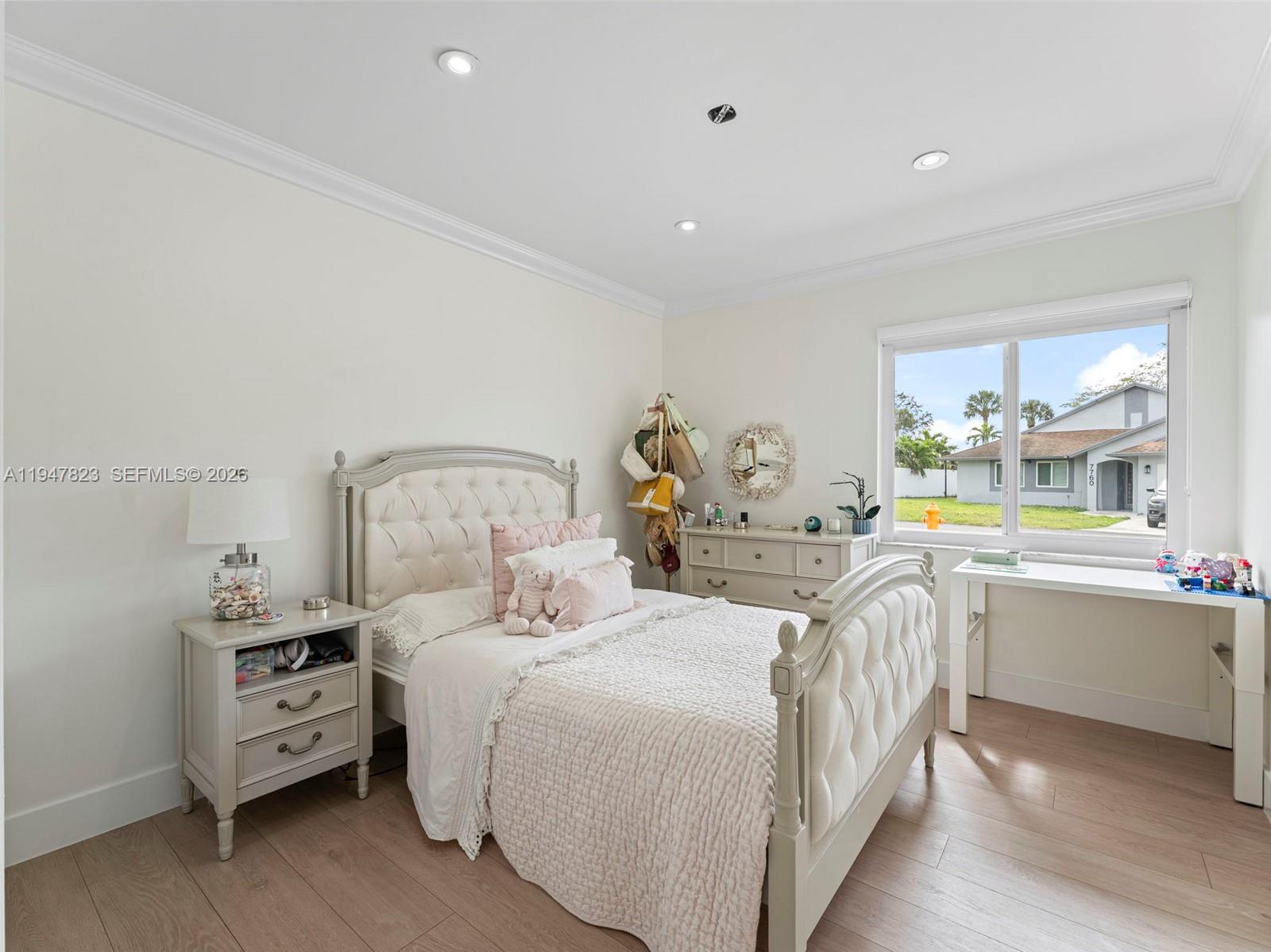 7753 Northwest 189th Street, Unit 1 Hialeah, FL 33015 - Photo 21 of 30 a bedroom with a bed and a large window