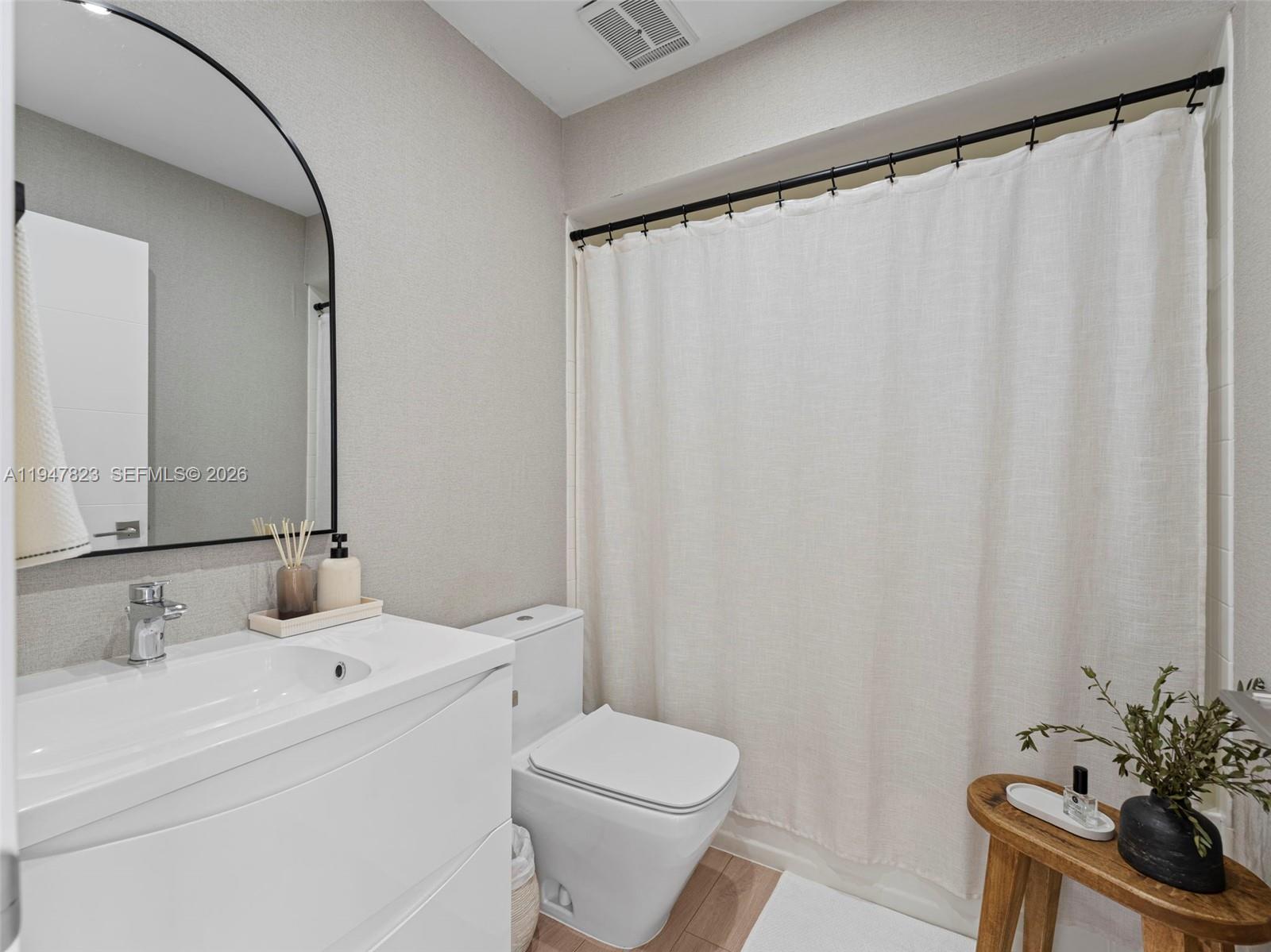7753 Northwest 189th Street, Unit 1 Hialeah, FL 33015 - Photo 25 of 30 a bathroom with a sink a toilet and a mirror
