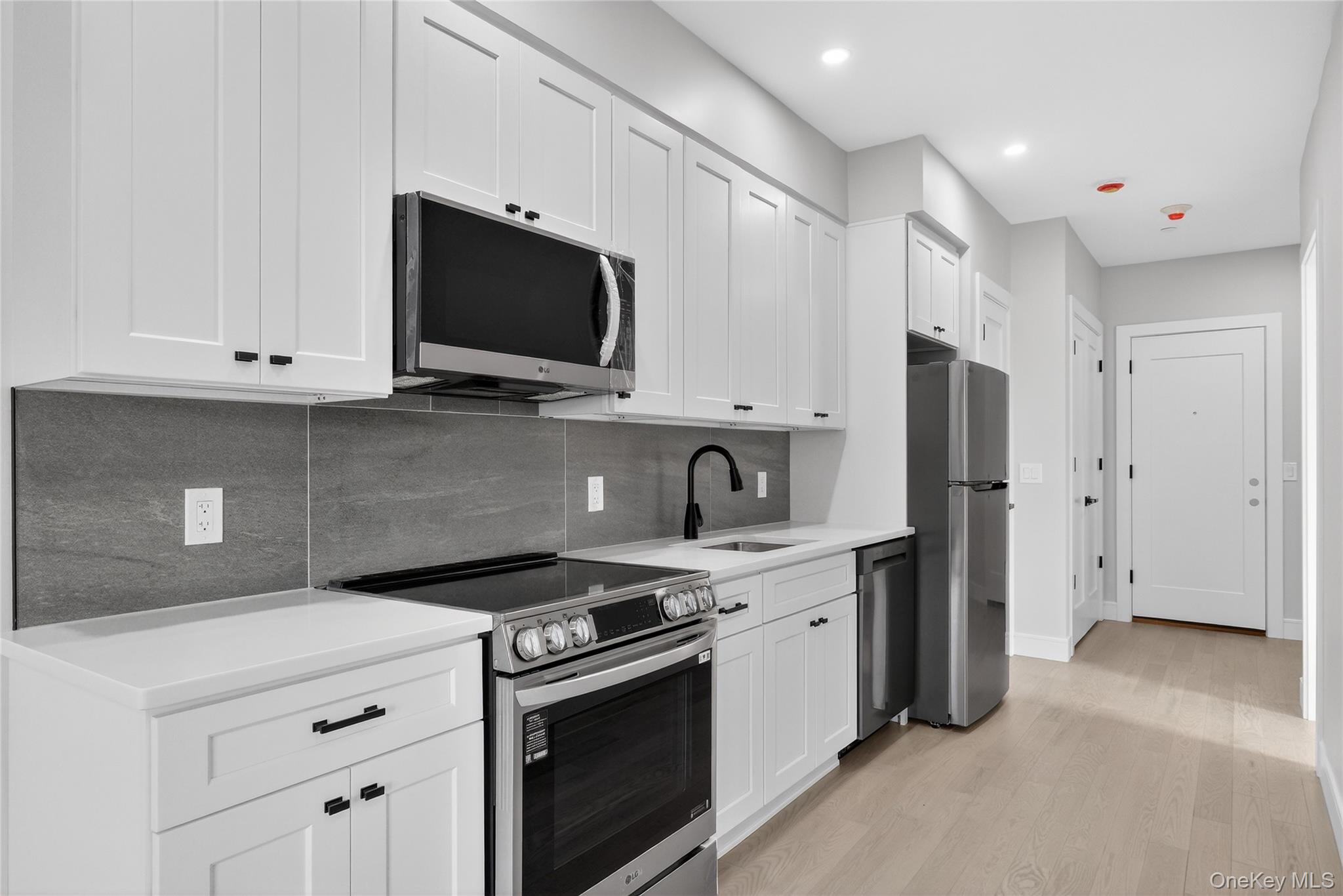 10 Market Street, Unit J Wappingers Falls, NY 12590 - Photo 8 of 18 a kitchen with stainless steel appliances white cabinets and a stove top oven