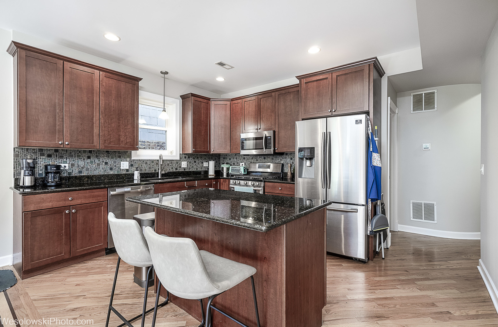 3042 North Oakley Avenue, Unit 2S Chicago, IL 60618 - Photo 6 of 19 a kitchen with stainless steel appliances granite countertop a refrigerator a stove a sink a dining table and chairs