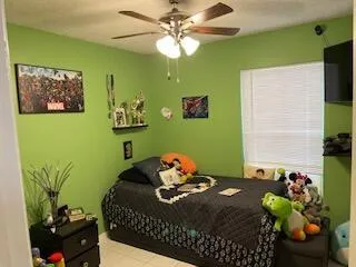 a bedroom with a bed potted plant and a potted plant