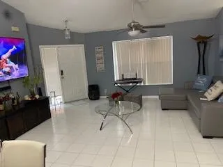a living room with furniture a chandelier and a flat screen tv