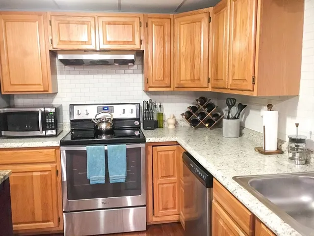 a kitchen with granite countertop stainless steel appliances and cabinets