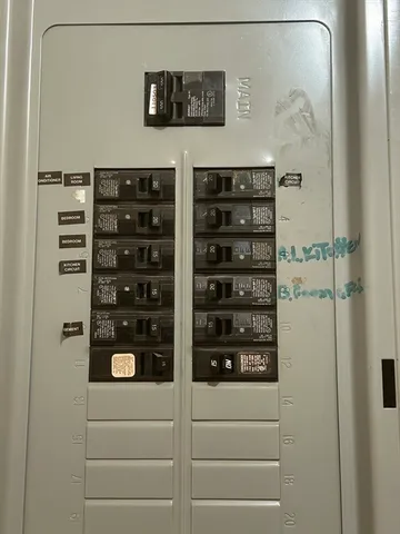 a view of a house with a barbeque and large windows