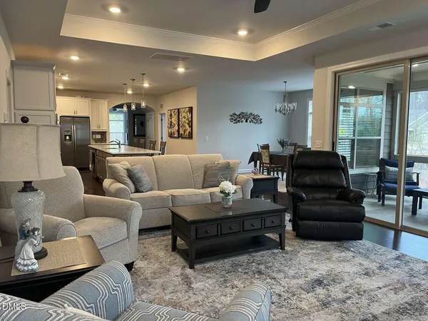 a living room with furniture and a dining table with wooden floor