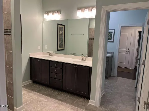 a bathroom with a double vanity sink a mirror and shower