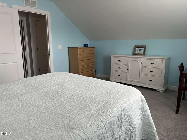 a bedroom with a bed and cabinet
