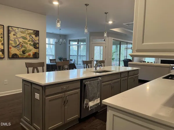 a large kitchen with a table chairs stainless steel appliances and cabinets