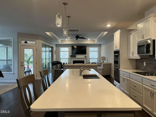 a kitchen with a refrigerator a sink and wooden floor