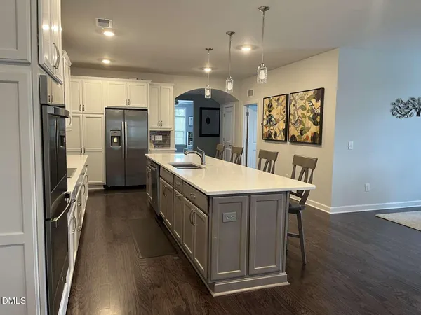 a kitchen with stainless steel appliances granite countertop a table chairs sink refrigerator and microwave