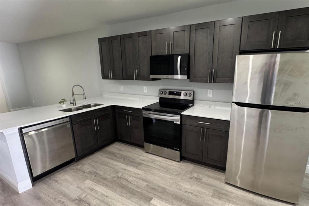 985 Northwest 57th Court, Unit 987 Ocala, FL 34482 - Photo 4 of 9 a kitchen with a sink appliances and cabinets