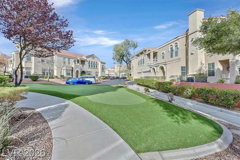 10550 West Alexander Road, Unit 2148 Las Vegas, NV 89129 - Photo 31 of 41 A community putting green awaits, nestled among warmly toned residential buildings.