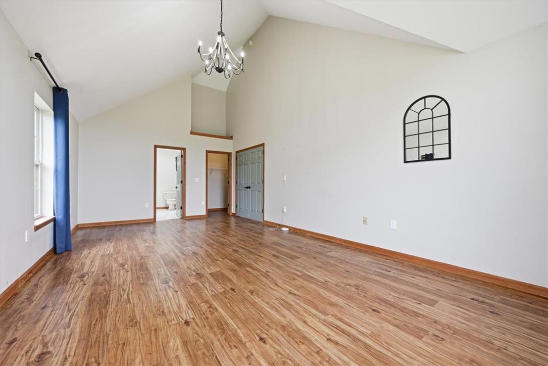 387 Blue Ridge Road Saylorsburg, PA 18353 - Photo 47 of 90 A vaulted ceiling crowns this spacious room, featuring elegant chandelier lighting and rich hardwood flooring.