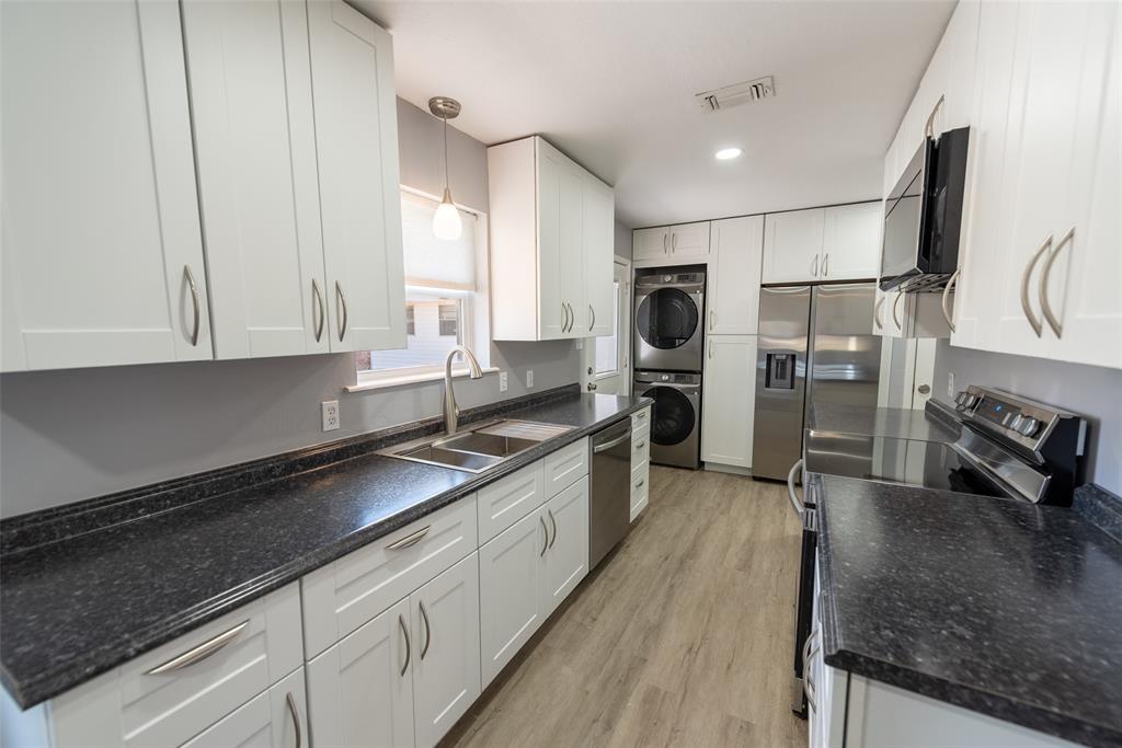 2339 Southwest County Road 3110 Mount Vernon, TX 75457 - Photo 11 of 31 a large kitchen with stainless steel appliances granite countertop a sink a stove and a refrigerator