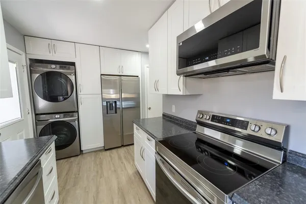 a kitchen with stainless steel appliances granite countertop a stove a sink and a microwave