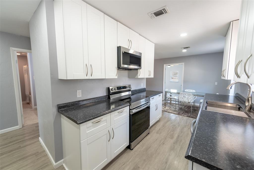 2339 Southwest County Road 3110 Mount Vernon, TX 75457 - Photo 13 of 31 a kitchen with stainless steel appliances granite countertop a stove a sink and a microwave