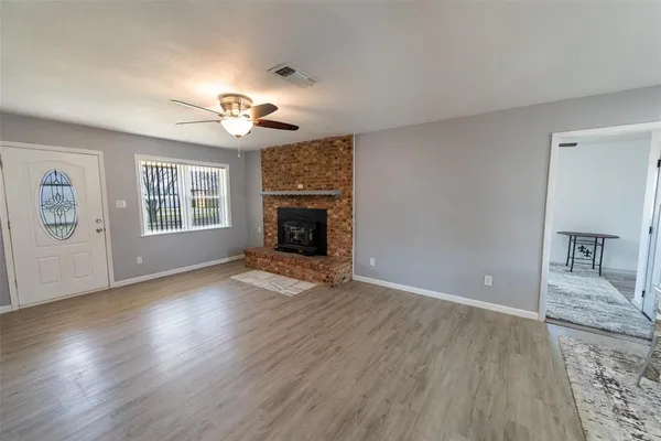 a view of a livingroom with a fireplace a chandelier and wooden floor
